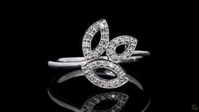 a close up of a diamond ring on a black surface