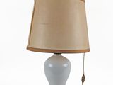 a white table lamp with a brown shade on it