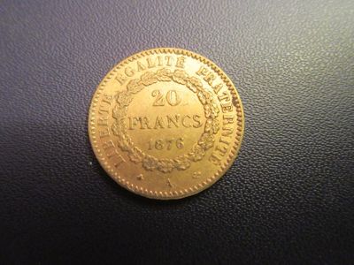 a close up of a gold coin on a black surface