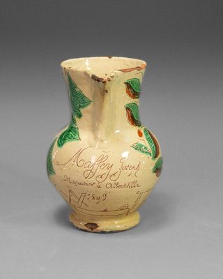 a small vase with writing on it sitting on a table