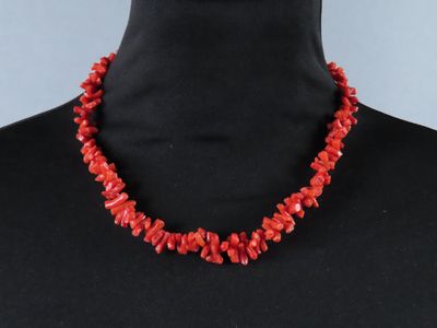 un collier de perles de corail rouge sur un mannequin, un mannequin, un mannequin, un mannequin, un mannequin, un mannequin, un mannequin, un mannequin