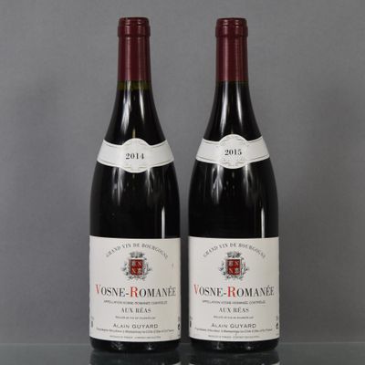 two bottles of wine sitting on top of a table next to each other