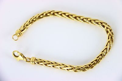 a gold bracelet with a braid design on a white background
