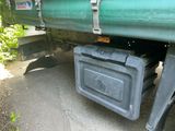 un camion vert avec un coffre noir en dessous