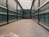 a long hallway in a building with green tiles on the walls