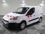 the white van is parked on a checkered floor in the garage