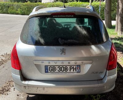 a silver car that is parked on the side of the road