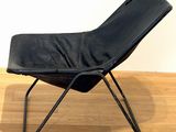 black leather lounge chair with metal legs on wooden floor