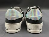 pair of black and white sneakers with hologized soles on a gray surface