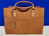 un sac à main marron posé sur une table près d'un mur bleu
