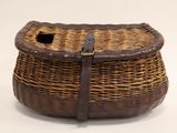 a wicker basket with a leather handle on a white background