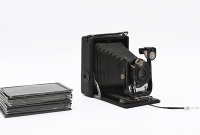 a black camera and a stack of books on a white surface
