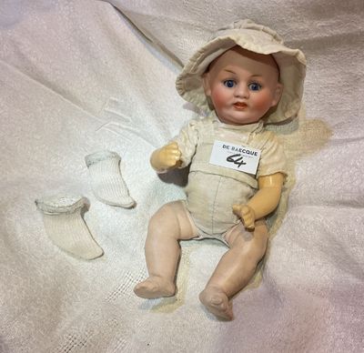 une poupée assise sur un drap blanc