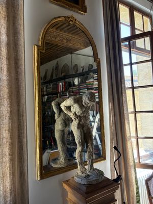 a statue in front of a mirror in a room
