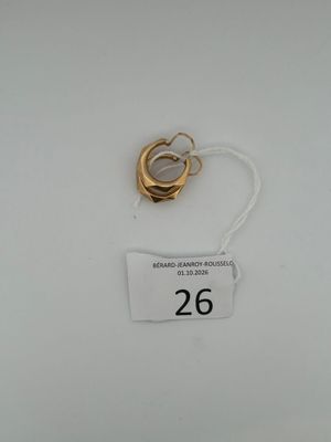 a gold ring and a white tag on a white surface