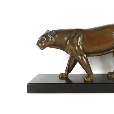statue d'un tigre posée sur un socle noir, devant un mur blanc