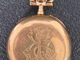 an old gold pocket watch sitting on top of a black surface