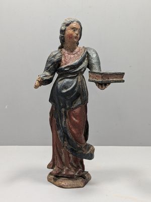 statue d'une femme tenant un plateau de nourriture posé sur une surface blanche