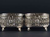 pair of silver plated bowls with ornate designs on them