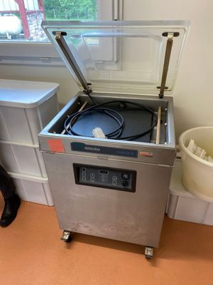 une machine posée sur le sol à côté d'une poubelle