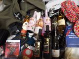many bottles of wine, books, and other items on the bed