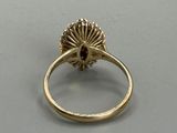 an image of a gold ring with a red stone in the center