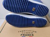 a close up of a pair of blue shoes on a box