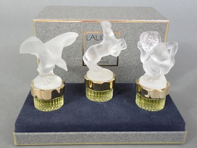 three glass figurines of birds sitting on top of a blue box