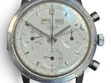 un gros plan d'une montre argentée posée sur une surface blanche