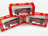 trois Ferrari rouges dans une boîte posée sur une surface blanche
