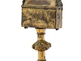 an old brass box on a stand on a white background