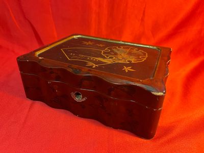 une vieille boîte en bois posée sur un tissu rouge