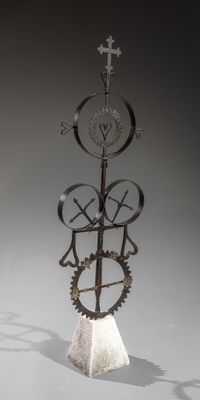 a sculpture of a clock with gears and a cross on top of it