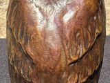 statue of an owl sitting on a table next to a vase
