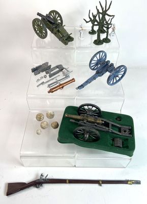 une vitrine contenant un pistolet, un fusil et d'autres objets