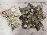 une liasse de billets et une pile de pièces posées sur une table