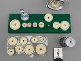 a close up of a green tray with a set of wheels and a puller