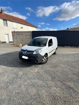 une camionnette blanche garée sur un parking à côté d'un bâtiment