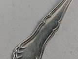 a silver spoon with a silver handle on a white surface