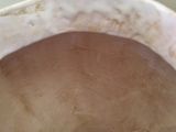 a close up of a white vase with a brown base