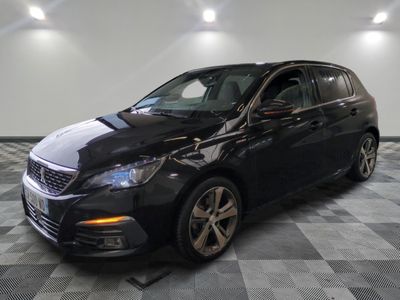 la voiture noire est garée sur un sol en damier dans le garage