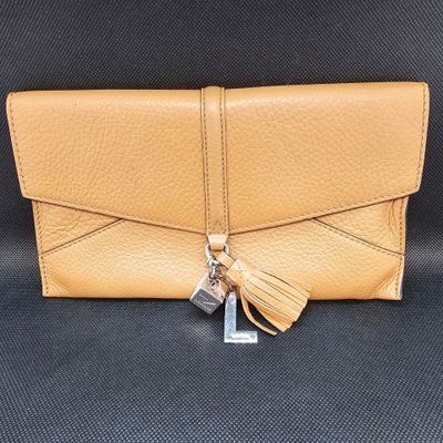 une photo d'un portefeuille en cuir beige orné d'un pompon