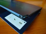 un ordinateur portable posé sur une table, avec une carte de visite accrochée dessus