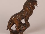 an image of a bronze statue of a lion on a rock