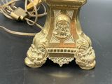 an antique brass table lamp with a gold shade on top of it
