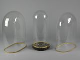 three clear glass vases with gold trims and a clock inside