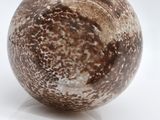 a close up of a marble ball on a white surface