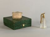 a small box with a candle on top of it next to a small glass bottle