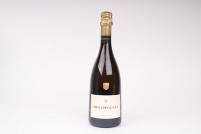 une bouteille de vin posée sur une table blanche