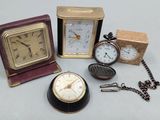 trois horloges et une montre de poche posées sur une table